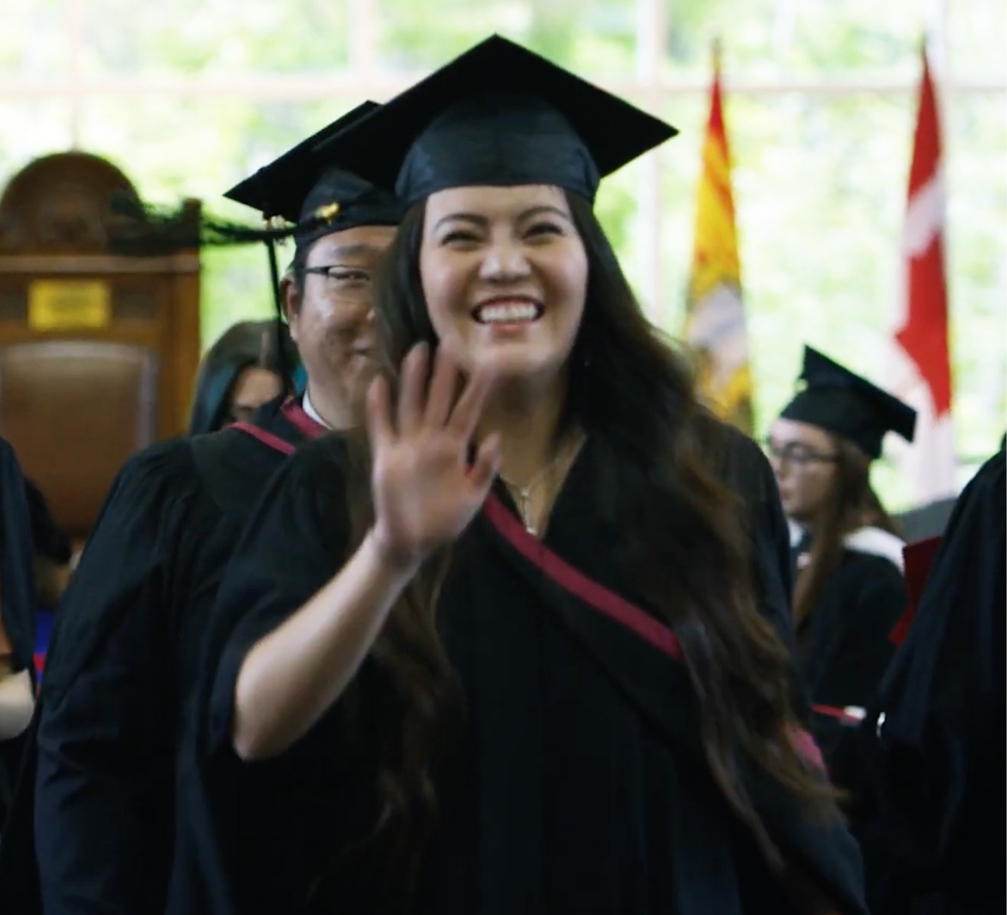 graduate smiling and waving
