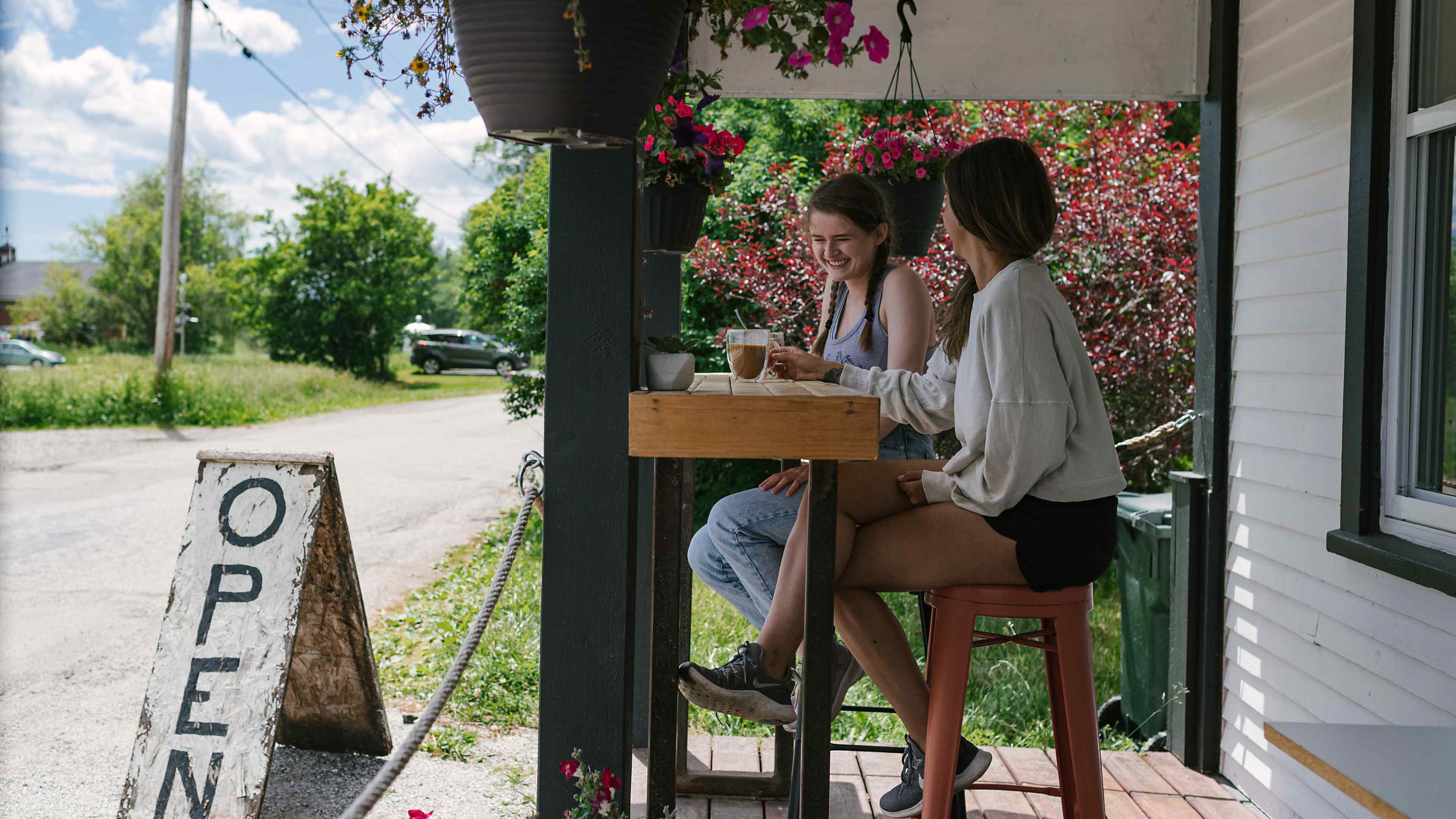 two women sitting on a cafe stoop