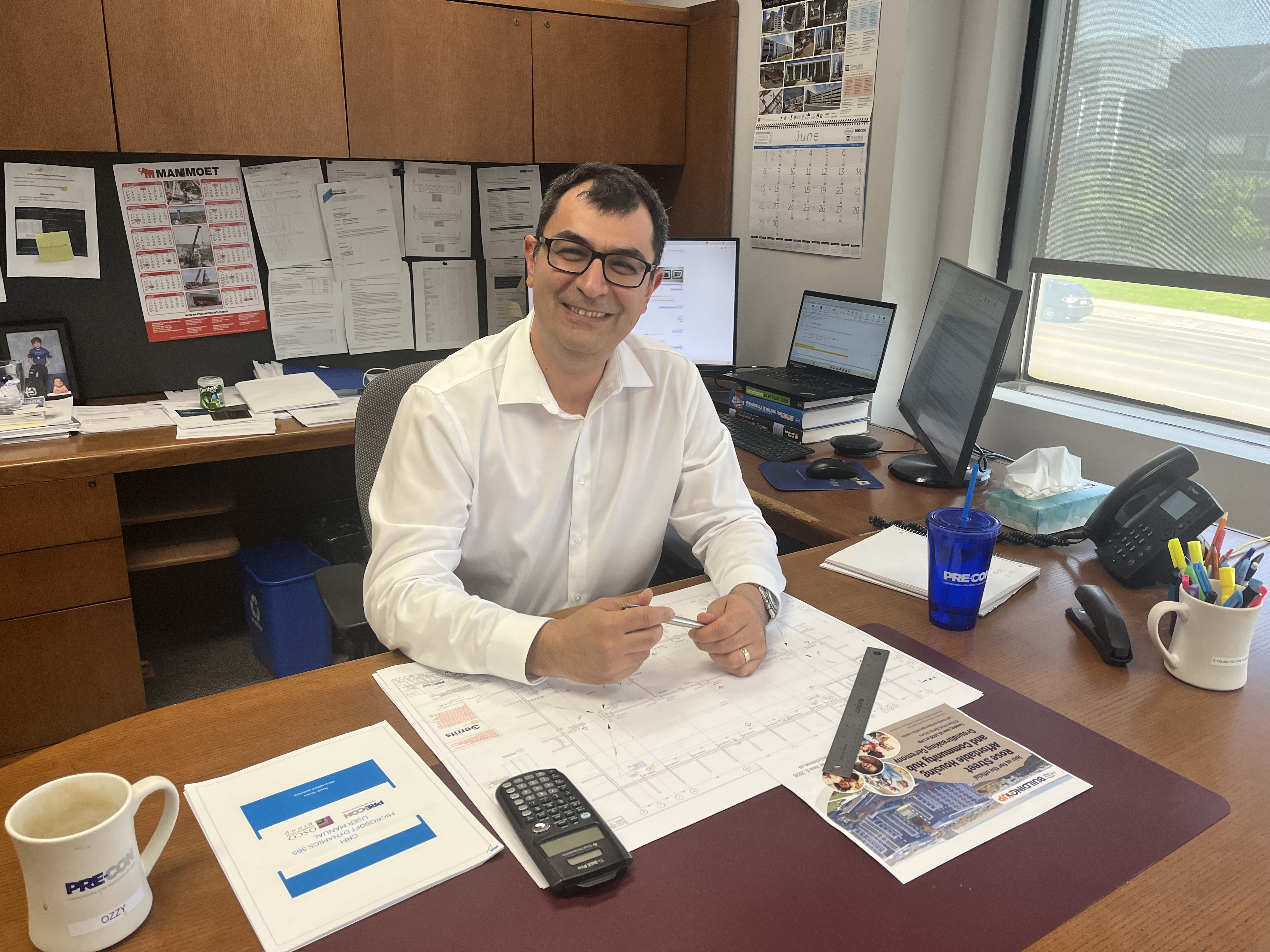 man sitting at his desk smiling 