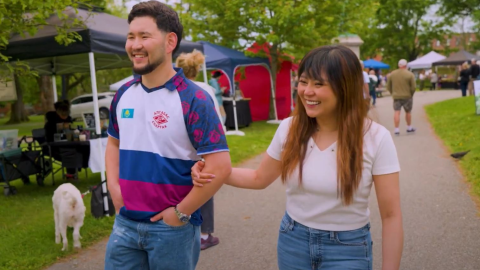 couple walking arm and arm laughing at market